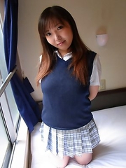 Haruka Ohsawa posing in her schoolgirl uniform and hiking up her top to show her big boobs